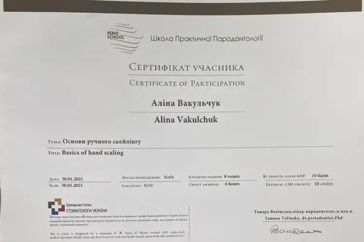 Стоматолог проводить ручний скейлінг зубів пацієнта спеціальними кюретами